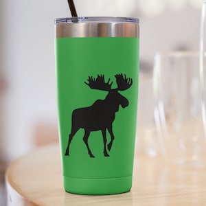 May include: A green stainless steel tumbler with a black moose silhouette design. The tumbler has a lid and a black straw.