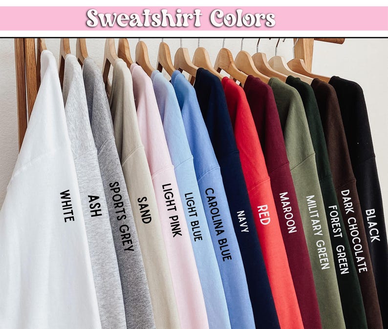 May include: A display of sweatshirts in various colors, including white, ash, sports grey, sand, light pink, light blue, Carolina blue, navy, red, maroon, military green, forest green, dark chocolate, and black.