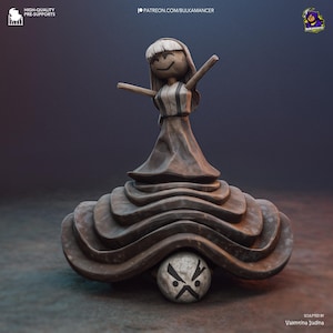 May include: A whimsical sculpture of a smiling figure with outstretched arms, atop a layered, textured base. The figure has a simple design with a dress and a round head. A small ball with a cross-shaped design rests beneath the base. The sculpture is a neutral color.