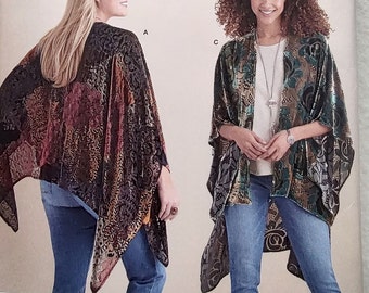 May include: A Simplicity 8479 sewing pattern envelope featuring two variations of a loose-fitting, open-front kimono-style wrap. The garments display intricate floral and botanical patterns in velvet textures, with additional illustrations of four distinct designs at the bottom.