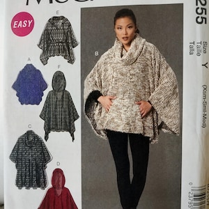 May include: A McCall's M7255 sewing pattern envelope for ponchos in size Y. The front displays a beige textured cowl-neck poncho and illustrations of five variations labeled A, B, C, D, E, and F, including hooded and non-hooded styles with various patterns.