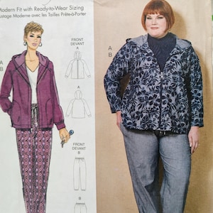 May include: A sewing pattern envelope featuring a hooded jacket and pants. The illustration shows a purple jacket and patterned pants. The photograph displays a dark blue floral print hooded jacket with a zipper, worn over a dark top with gray pants.