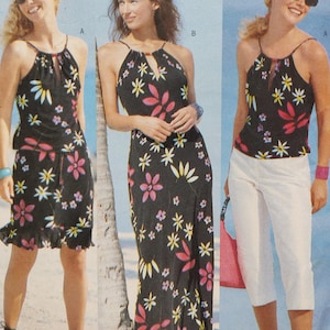 May include: Three women's outfits featuring black tops and skirts or pants with floral patterns. The tops have a halter neck design. The floral patterns include pink, yellow, and white flowers. One outfit includes white capri pants.
