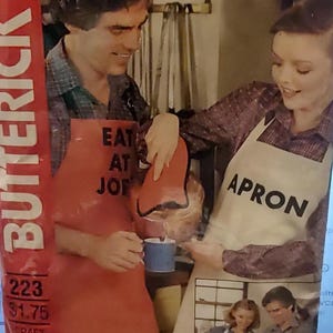 May include: Two people wearing aprons, one red with the text "Eat at Joe's" and the other white with the text "Apron".