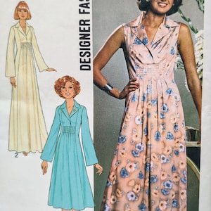 May include: A Simplicity sewing pattern envelope featuring the text Designer Fashion and Look Slimmer pattern. It displays illustrations of a long-sleeved cream dress and a blue dress, plus a photograph of a sleeveless pink floral dress.