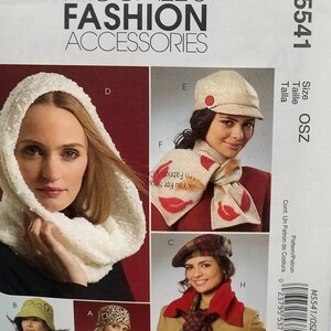 May include: McCall's Fashion Accessories sewing pattern M5541 for various headwear and scarves. The envelope displays a white textured hood, a beige cap with a red button, a beige scarf with red leaf prints, a plaid beret, and a plaid scarf.
