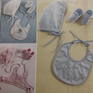 May include: Simplicity pattern 2673 featuring baby clothing sets. The sets include bonnets, bibs, and booties. The bibs are embroidered with the words "Sweetie" and "Baby". The pattern is designed by Teri.