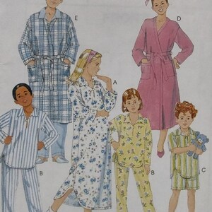 May include: A pattern sheet featuring various children's sleepwear designs. The styles include a long floral nightgown, striped pajamas, a pink robe, and a plaid robe. The sleepwear is designed for children of different ages and sizes.