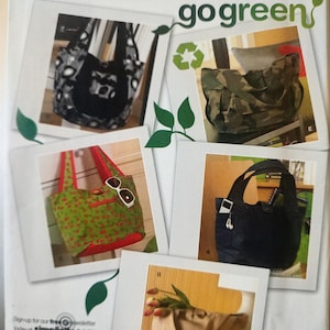 May include: Simplicity sewing pattern featuring various tote bags. The bags include a black and white patterned tote, a camouflage tote, a green tote with a cherry pattern, and a black tote. The text "go green" is visible.