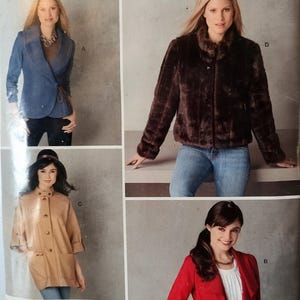 May include: A Simplicity sewing pattern envelope, number 2150, featuring four jacket designs: a blue wrap jacket, a dark brown faux fur jacket, a tan button-up jacket with a high collar, and a red open-front jacket with ruffled lapels.