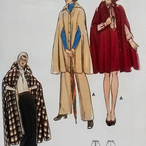 May include: A sewing pattern illustration featuring three cape designs. One cape is plaid with black trousers, one is beige worn over matching trousers and a blue top, and one is deep red worn over a matching skirt and a striped blouse.