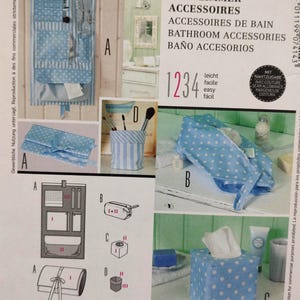 May include: Image of bathroom accessories, including a hanging organizer, a makeup brush holder, a tissue box, and a travel bag. The items are made of blue and white polka dot and striped fabric. The image also includes text in multiple languages.