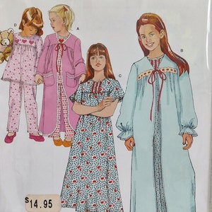 May include: Simplicity sewing pattern number 1569 for girls' nightgowns and pajamas. The pattern includes three different styles: a long-sleeved nightgown with a tie at the neck, a short-sleeved nightgown with a floral print, and a pink robe with a white gingham trim. The pattern is for sizes 3-6.
