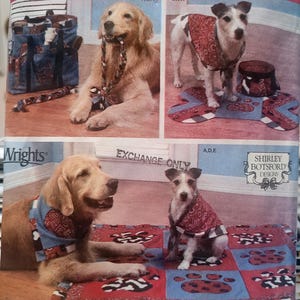 May include: A Simplicity sewing pattern envelope 4061 for pet accessories featuring illustrations of dogs wearing bandanas and vests, with a tote bag, a bone-shaped mat, and a square quilt. The packaging includes the text Simplicity, Wrights, and Shirley Botsford Designs.