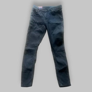 Könnte beinhalten: Dunkelblaue Jeans mit mehreren Taschen und schmaler Passform.