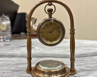 Relógio de mesa com mostrador de latão gravado personalizado e bússola integrada na base.