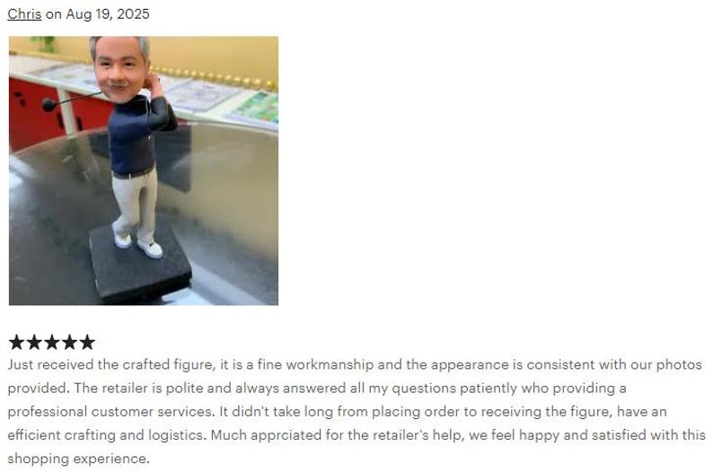 May include: A custom bobblehead figure of a golfer with gray hair, wearing a dark blue long-sleeved shirt and light gray trousers. The figure is posed in a golf swing motion, holding a golf club, and is mounted on a square black base.