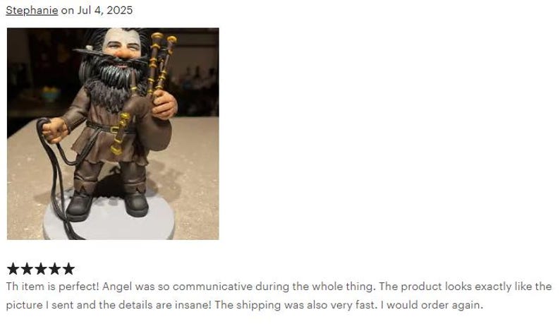 May include: A figurine of a bearded character wearing a brown tunic and dark trousers, holding a set of bagpipes with gold-colored accents. The figure has long dark hair, a full beard, and stands on a circular base, featuring detailed textures.