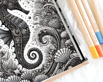 May include: Black and white seahorse coloring book page with intricate details, surrounded by seashells and ocean elements. Includes four pencils with the text "Boss Lady" on them, with yellow, orange, and blue tips. The image is on a white, fluffy surface.