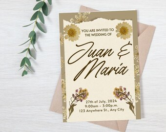 May include: A wedding invitation with a rustic, floral design. The invitation is printed on cream paper with dried flowers and the text "YOU ARE INVITED TO THE WEDDING OF Juan & Maria 27th of July, 2024 9:00am - 3:00p.m. 123 Anywhere St., Any City".