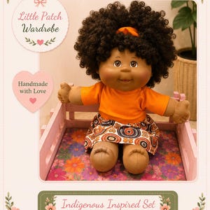 May include: A doll with dark curly hair and brown skin wearing an orange short-sleeved shirt and a skirt featuring a circular pattern in orange, black, and white. The doll is seated in a light pink wooden frame. Text includes Little Patch Wardrobe.