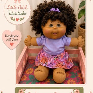 May include: A doll with dark curly hair, brown skin, and brown eyes, wearing a light purple short-sleeved shirt and a pink skirt with a colourful patterned design. The doll has a small purple hair accessory and is seated in a light pink wooden frame.