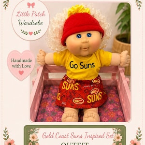 May include: A doll with curly blonde hair wearing a red beanie, a yellow t-shirt with the text Go Suns, and a red skirt featuring the Gold Coast Suns logo and text. The doll is seated in a pink wooden crate with a floral patterned base.