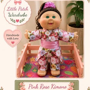 May include: A doll with dark brown hair in a ponytail and green eyes wearing a pink floral kimono outfit with a matching satin sash. The doll is standing in a pink wooden crate. Text on the image reads Little Patch Wardrobe and Pink Rose Kimono OUTFIT.