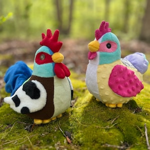 May include: Two colorful plush toy chickens. One chicken is blue, brown, white, and red. The other chicken is yellow, pink, and purple.