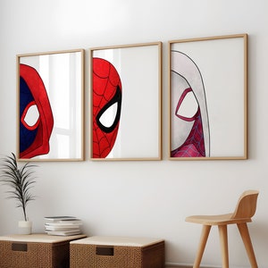 May include: Three framed art prints featuring the iconic masks of Deadpool, Spider-Man, and Spider-Gwen. The artwork showcases the characters' faces against a white background, with wooden frames. The room includes a wooden chair and woven storage bins.