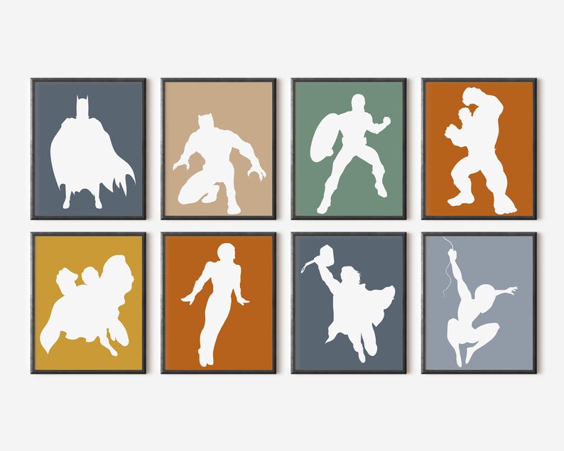 May include: Eight framed art prints featuring white superhero silhouettes against colorful backgrounds. The prints showcase iconic characters in action poses, including Batman, Captain America, and Spider-Man. The frames are black.