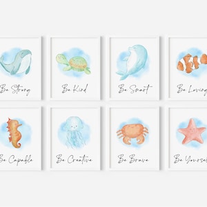 Op de afbeelding: Set van acht aquarelprints met verschillende zeedieren met inspirerende boodschappen. De prints bevatten een walvis, schildpad, dolfijn, clownvis, zeepaardje, kwal, krab en zeester. Elke print heeft een andere boodschap, zoals "Wees sterk", "Wees aardig", "Wees slim", "Wees liefdevol", "Wees bekwaam", "Wees creatief", "Wees dapper" en "Wees jezelf".