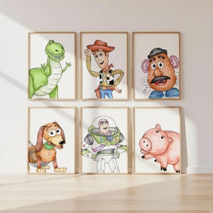 May include: Six framed watercolour prints featuring characters from a popular animated film. The characters include a green dinosaur, a cowboy, Mr. Potato Head, a dachshund, a space ranger, and a pink pig.
