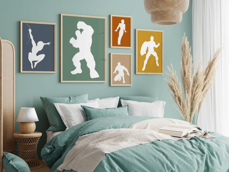 May include: A bedroom scene with framed superhero art. The wall art features white silhouettes on colored backgrounds. The bed has teal bedding and white pillows. A woven lamp and side table are on the left.