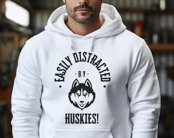 May include: White hooded sweatshirt with black text that reads "Easily Distracted by Huskies!" with a black and white husky silhouette.