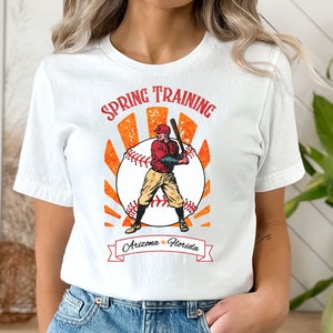 May include: White t-shirt with a vintage baseball graphic and the text "Spring Training Arizona * Florida".