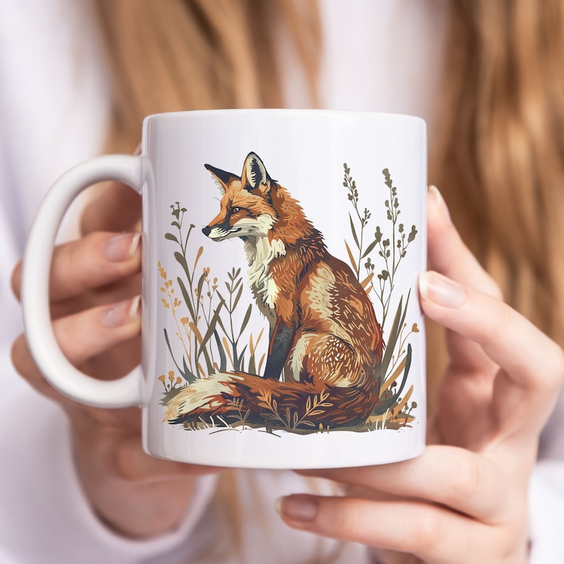 May include: White ceramic mug with a colorful illustration of a fox sitting in a field of tall grass. The fox is facing left and has a bushy tail.