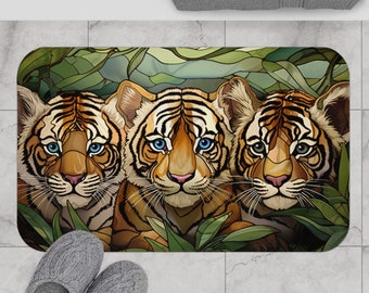May include: Three tiger cubs with blue eyes peek out from behind green leaves. The cubs are brown and orange with black stripes. The background is a stained glass pattern of green leaves.