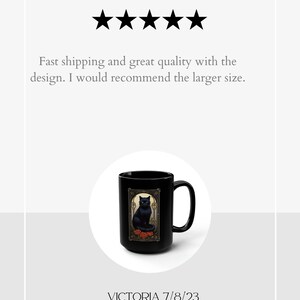 May include: Black ceramic coffee mug with a black cat illustration and red roses. The mug has a white rim and handle. The text "REVIEW" and five stars are above the mug. The text "VICTORIA 7/8/23" is below the mug.