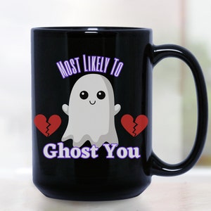 May include: Black coffee mug with a white ghost and two broken red hearts. The text "Most Likely To Ghost You" is printed in purple on the mug.