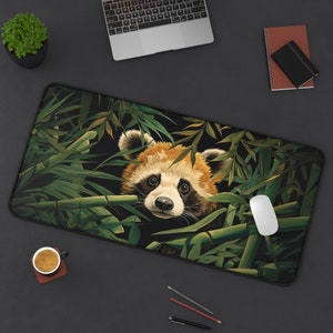May include: A black and green mouse pad with a red panda peeking out from behind bamboo leaves. The panda has black eyes and a white nose.