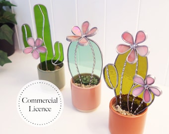 May include: Three stained glass cactus plants in terracotta pots. The cacti are green, blue, and yellow with pink flowers. The text "Commercial Licence" is visible in the image.