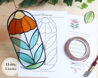 May include: A stained glass floral pattern featuring a flower and stem. The pattern is printed on white paper with numbered sections. The pattern is titled "Botanical Moments" and is a digital download.