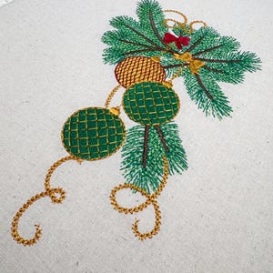 May include: Embroidered Christmas ornament design featuring green and gold ornaments with a red bow hanging from a green pine branch.