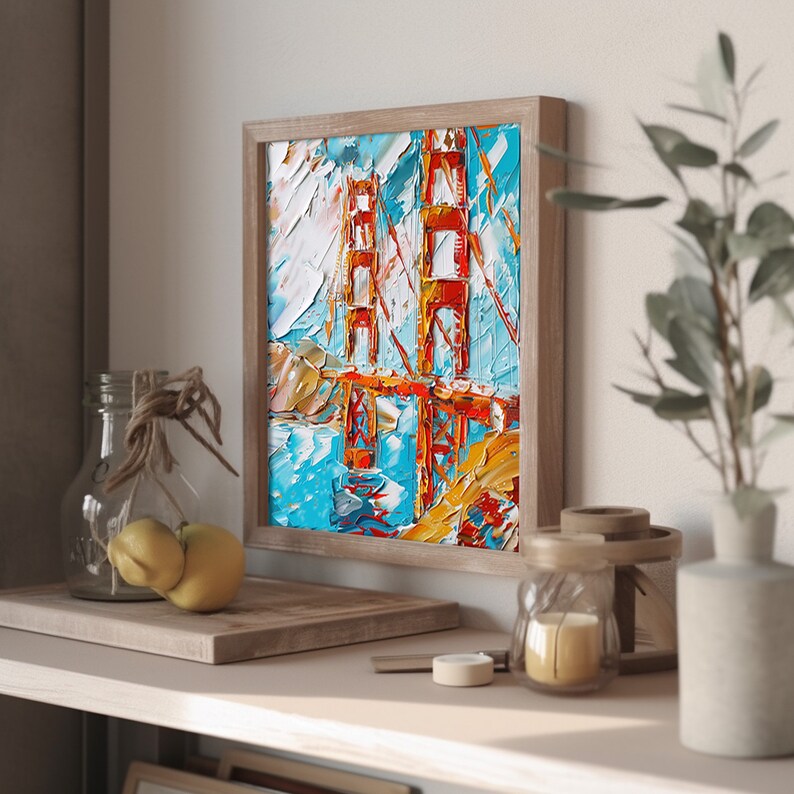 May include: A framed painting depicting the Golden Gate Bridge in San Francisco. The artwork is created in a colourful, abstract style with thick brushstrokes. The bridge is painted in shades of red and orange, with the water below in shades of blue and green.