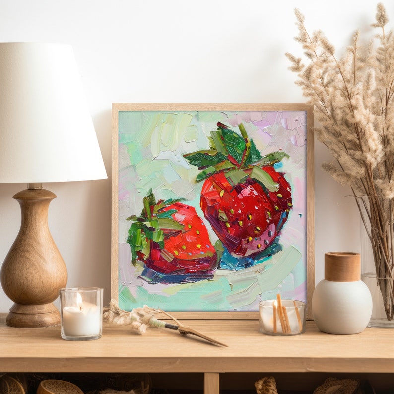 May include: A framed painting of two red strawberries on a light green background. The strawberries are painted in a thick, textured style, with visible brushstrokes. The painting is framed in a light wood frame.