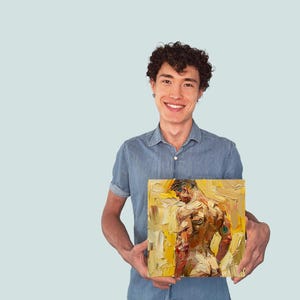 Puede incluir: Una persona sosteniendo una pintura de una figura masculina desnuda en un esquema de color amarillo y naranja. La pintura est&aacute; enmarcada y tiene un estilo de pincelada texturizada.