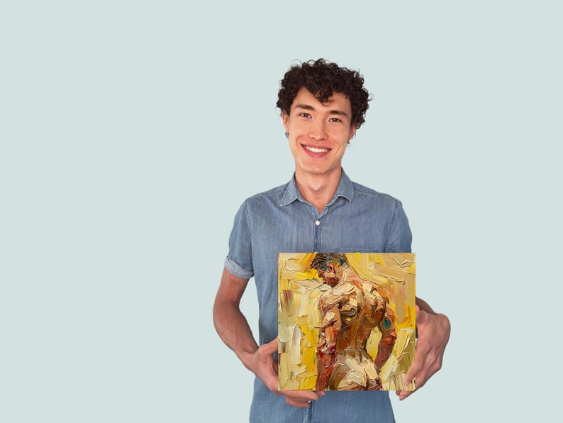 Puede incluir: Una persona sosteniendo una pintura de una figura masculina desnuda en un esquema de color amarillo y naranja. La pintura est&aacute; enmarcada y tiene un estilo de pincelada texturizada.