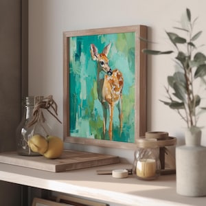 Puede incluir: Pintura enmarcada de un ciervo con pelaje marr&oacute;n claro y manchas blancas, sobre un fondo turquesa y verde. La obra de arte est&aacute; en un marco de madera, creando una est&eacute;tica r&uacute;stica. La pintura se exhibe en una estanter&iacute;a con otros objetos decorativos.