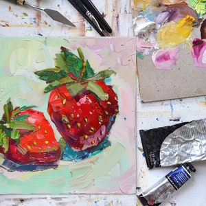 May include: A close-up of a painting of two red strawberries with green leaves on a light green background.